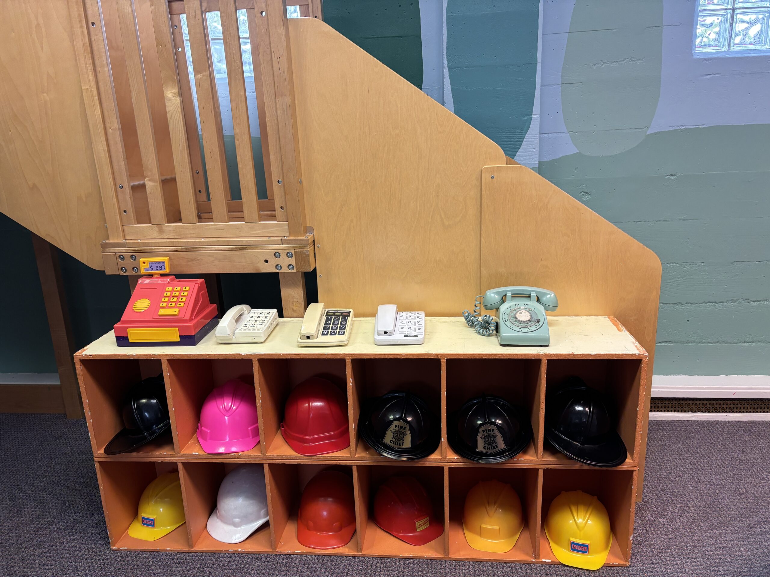 Cubbies filled with dress up hats and play telephones.